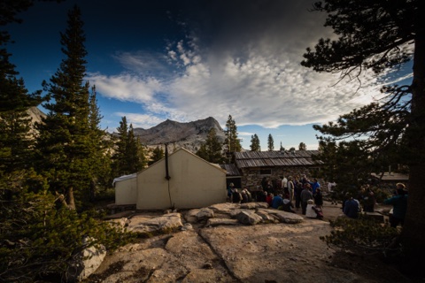 The dinner crowd at the dining hall under a dramatic evening sky.