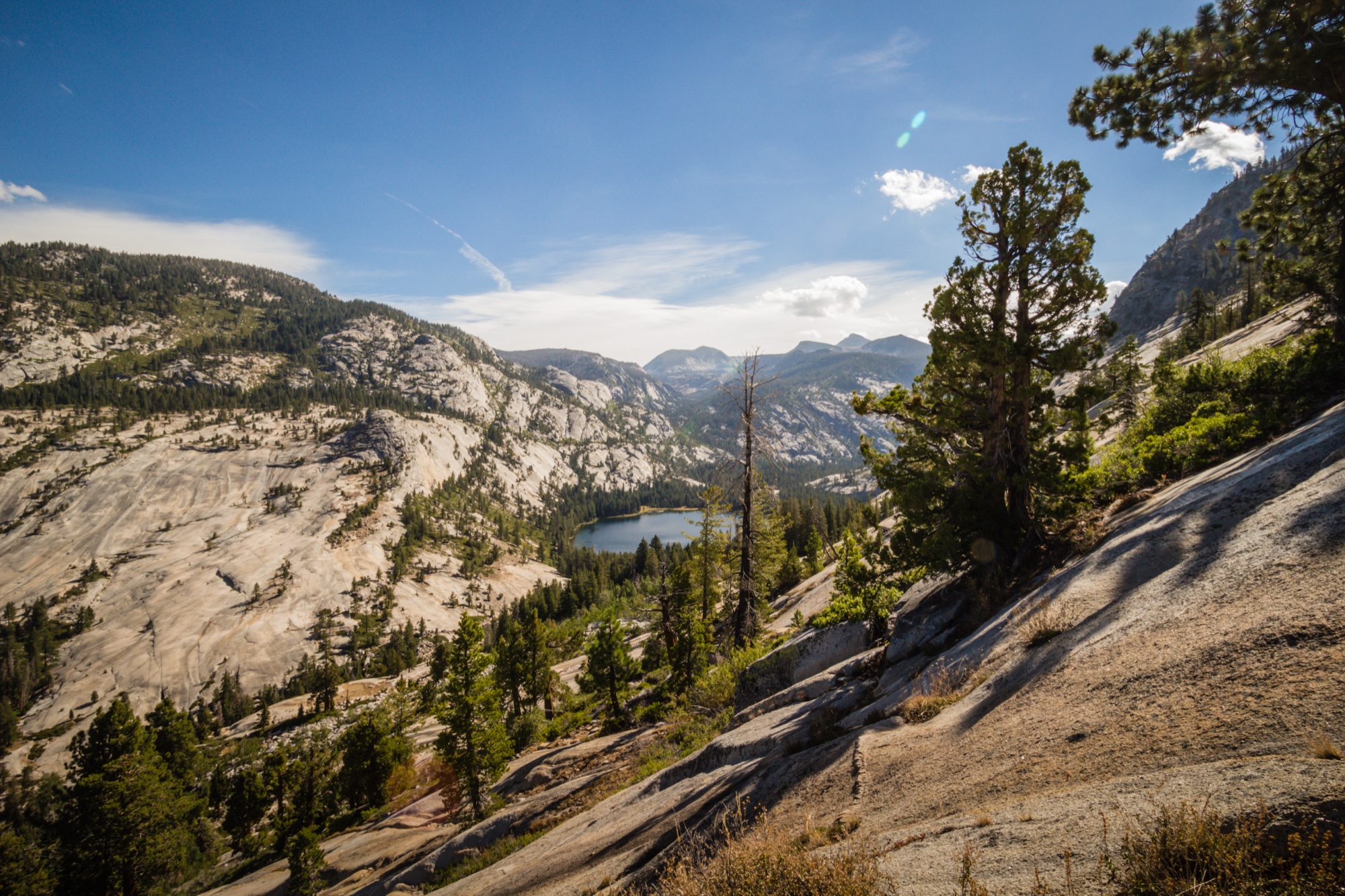 Granite slopes and pines dropping to a small lake