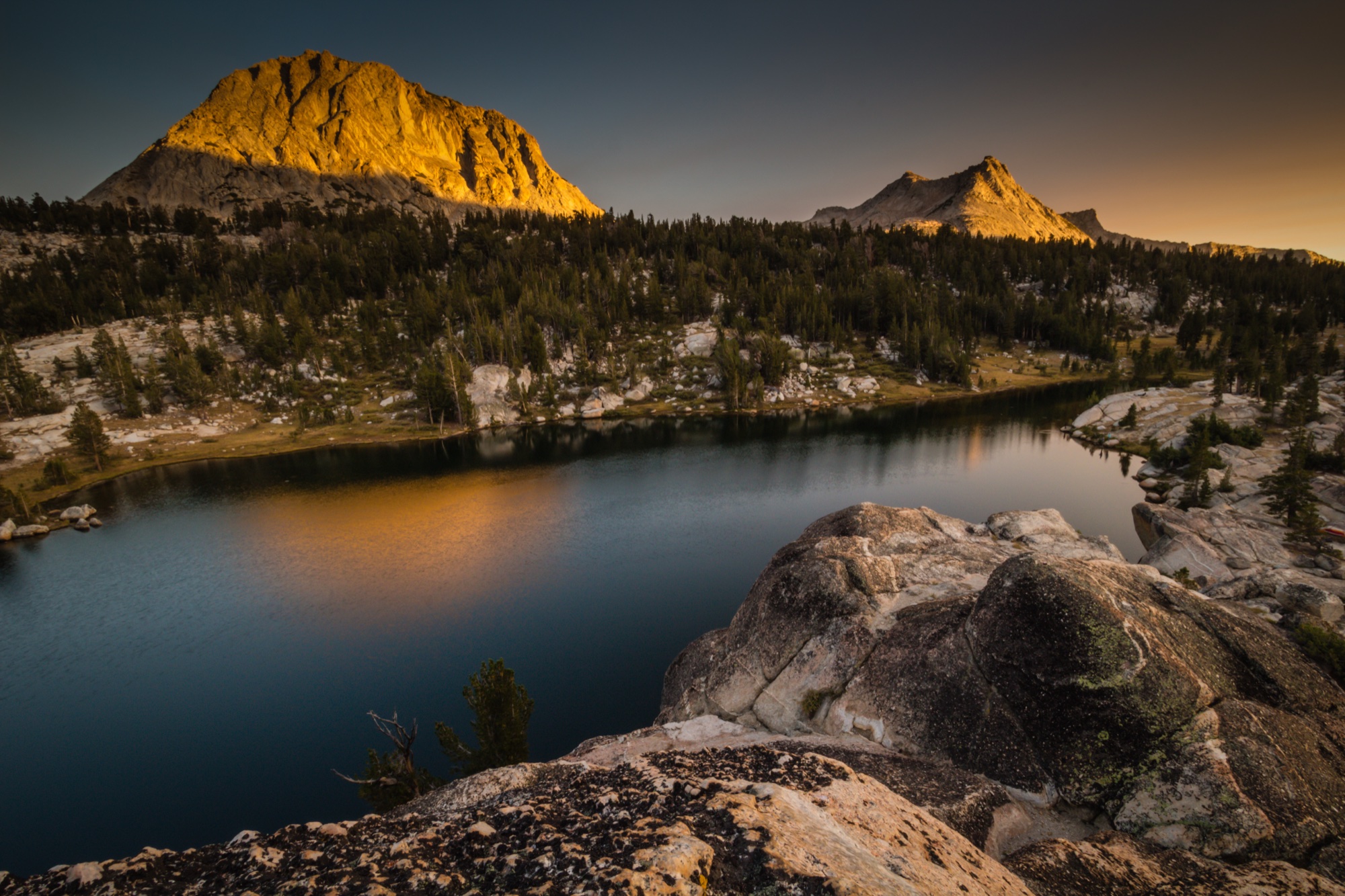 Alpenglow on a granite peak above a still high-country lake
